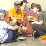 Deb Meese, Eric Martin, and Mary Malkiel chatting as Seeley enjoys some pets